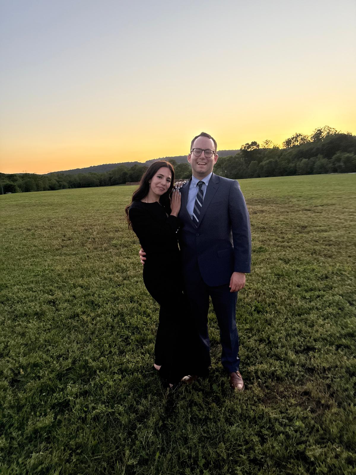 Nathalie and David dressed up in a field at sunset